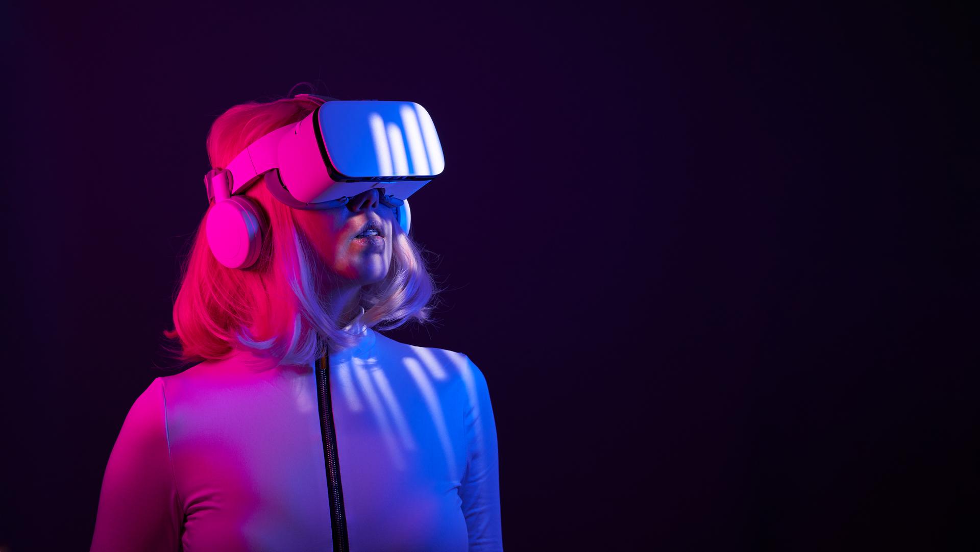 Woman in virtual reality goggle in neon colors.